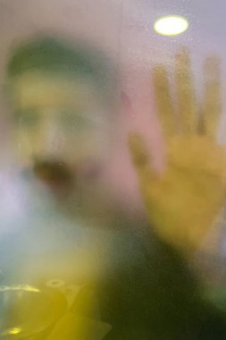 Sisli cam duş kapısının arkasındaki genç adam.