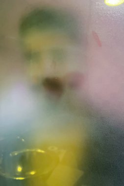 Sisli cam duş kapısının arkasındaki genç adam.