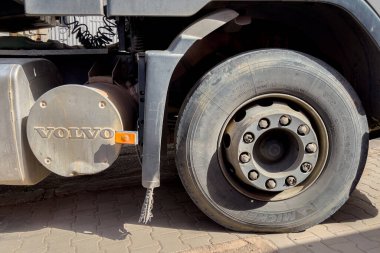 Yol kenarına park etmiş büyük lastikleri olan bir Volvo kamyonu.