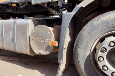 Yol kenarına park etmiş büyük lastikleri olan bir Volvo kamyonu.