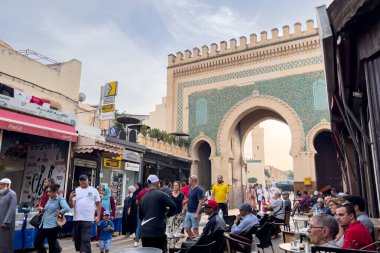 People walking nearby the blue gate in the medina of Fez