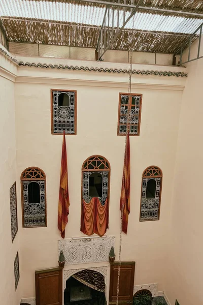 Geleneksel el yapımı kumaşlar Fas 'ta bir Riad' ın avlusunda camdan sarkıyor.