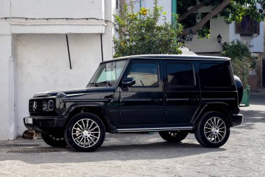 Siyah Mercedes AMG G63 sokağa park edilmiş.