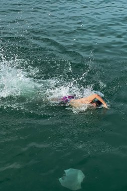 Genç adam denizde yüzüyor.