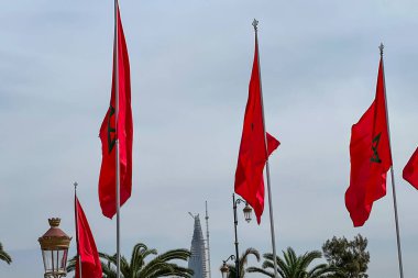 Arka planda bulutlu bir gökyüzü dalgalanan Fas bayrakları