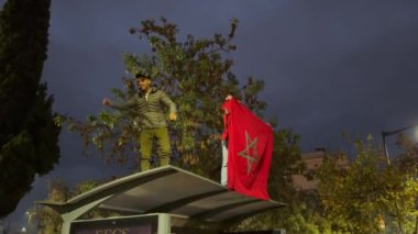 Faslı taraftarlar, FIFA Dünya Kupası Katar 2022 'de milli takımının zaferinden sonra yolları kapatan bayraklar sallıyor.