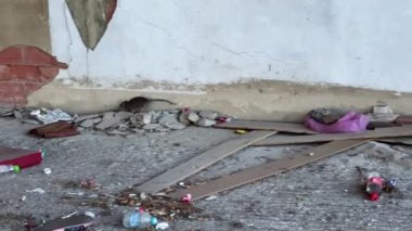 Şehirde terk edilmiş bir garajın içinde yiyecek arayan vahşi bir fare.