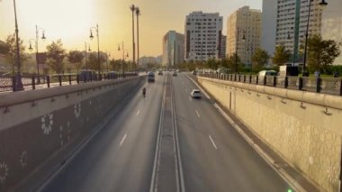 Arabalar Tanger 'de bir yeraltı tüneline giriyor ve arka planda günbatımı gökyüzü var.