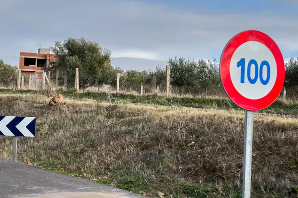 100 Km speed limit signpost on the roadside of a highway