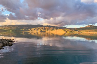 Silhouette reflection of the sunset on a large dam