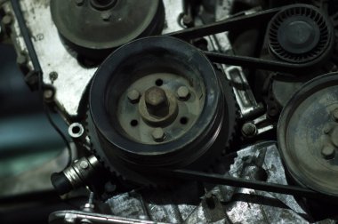 Tamir edilen eski bir motor, eski gri bir arabaya yerleştirilmeden önce besleniyor.