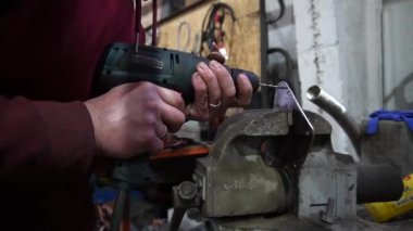 Bir çilingir metal sondaj yapar, bir araba için özel parçalar yapar.