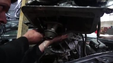 Motor tamiri, akort için gri eski bir arabadan çıkarılıyor