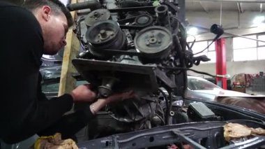 Motor tamiri, akort için gri eski bir arabadan çıkarılıyor