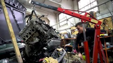 Motor tamiri, akort için gri eski bir arabadan çıkarılıyor