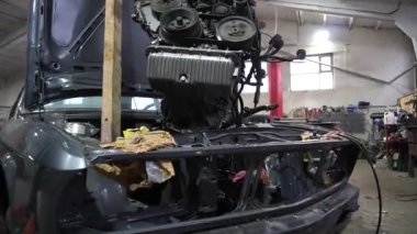 Motor tamiri, akort için gri eski bir arabadan çıkarılıyor