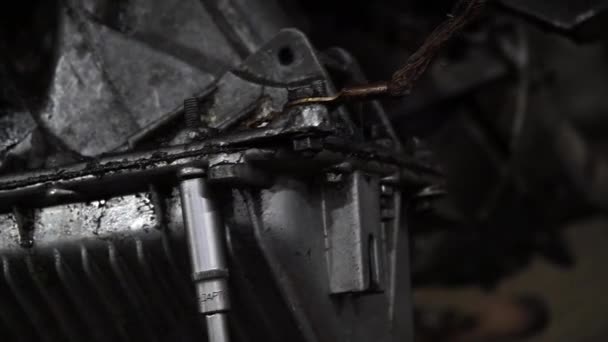 整備士は修理とチューニングのため赤いリフトに古い汚い車のエンジンを分解します — ストック動画