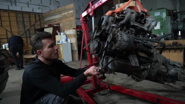 Mecanic Dezasamblează Motor Vechi Mașină Murdară Lift Roșu Pentru Reparații — Videoclip de stoc