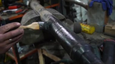 Cardan şaftı bir tamirci onarmak ve akort etmek için kırmızı asansörde eski bir kirli araba motorunu söker.
