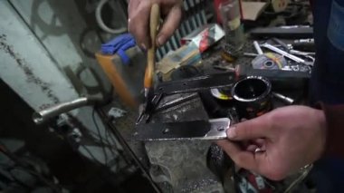 Bir tamirci tamir ve akort için kırmızı asansörde eski kirli bir araba motorunu söker.