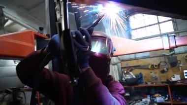 Kaynakçı, özel arabalar için metal yapıların kaynak işlerini yapıyor.