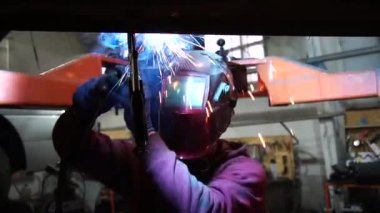 Kaynakçı, özel arabalar için metal yapıların kaynak işlerini yapıyor.