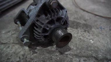 Bir tamirci tamir ve akort için kırmızı asansörde eski kirli bir araba motorunu söker.