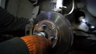 Bir tamirci tamir ve akort için kırmızı asansörde eski kirli bir araba motorunu söker.