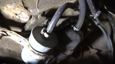 Bir tamirci tamir ve akort için kırmızı asansörde eski kirli bir araba motorunu söker.