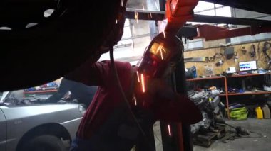 Kaynakçı, özel arabalar için metal yapıların kaynak işlerini yapıyor.