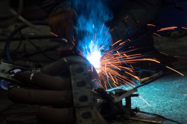 long exposure photo welder performs welding works of metal structures for custom cars