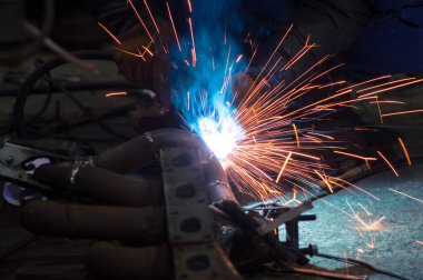 long exposure photo welder performs welding works of metal structures for custom cars