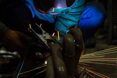 long exposure photo welder performs welding works of metal structures for custom cars