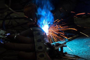 long exposure photo welder performs welding works of metal structures for custom cars