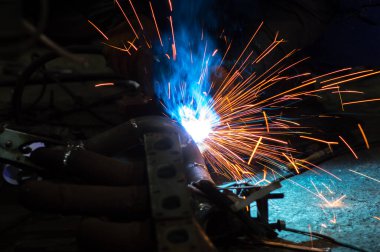 long exposure photo welder performs welding works of metal structures for custom cars