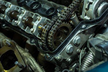 a mechanic disassembles an old dirty car engine on a red lift for repair and tuning turbo car