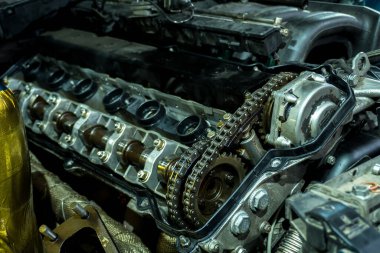 a mechanic disassembles an old dirty car engine on a red lift for repair and tuning turbo car