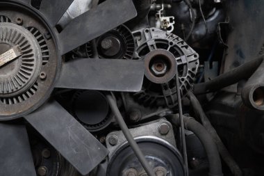 a mechanic disassembles an old dirty car engine on a red lift for repair and tuning turbo car