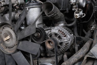 a mechanic disassembles an old dirty car engine on a red lift for repair and tuning turbo car