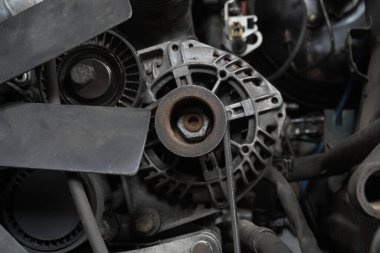 a mechanic disassembles an old dirty car engine on a red lift for repair and tuning turbo car