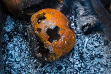 Bahçedeki yangının külleri içinde balkabağı.