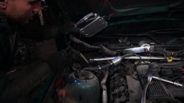 Bir tamirci, turbo motor ayarlama sürücüsünü yüklemek için bir arabayı söker