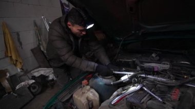 Bir tamirci, turbo motor ayarlama sürücüsünü yüklemek için bir arabayı söker