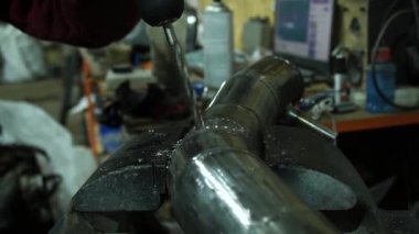 bir çilingir metal sondaj yapar, bir araba egzoz manifoltu için özel parçalar yapar ve turbo motor için emme sistemi