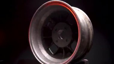 Eski arabanın tekerlekleri titanyum jantlar eski alaşımlı jantlar karanlık bir odada zaman ayarlı video çekimi.