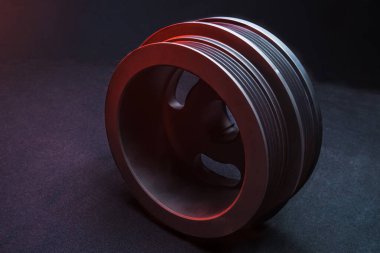 CNC makinesinde yapılmış bir motor için yeni bir makara. Koyu arkaplanda birçok kılavuz var.