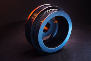 CNC makinesinde üretilen motordaki araba için yeni makara. Kırmızı ve mavi ışıkta çok yönlü.