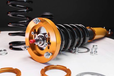 süspansiyon ayarı, bobinler, şok emiciler ve sarı ve altın renkli ön yaylar koyu arka planda bir spor drift araba için