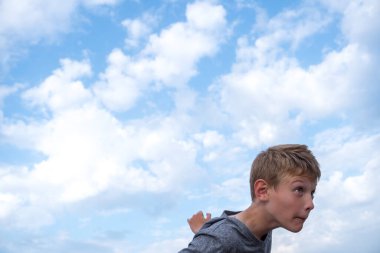 Bir çocuk futbol topuna tekme atıp kafa atmaya hazırlanıyor.