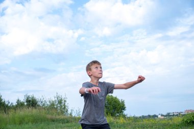 Bir çocuk futbol topuna tekme atıp kafa atmaya hazırlanıyor.